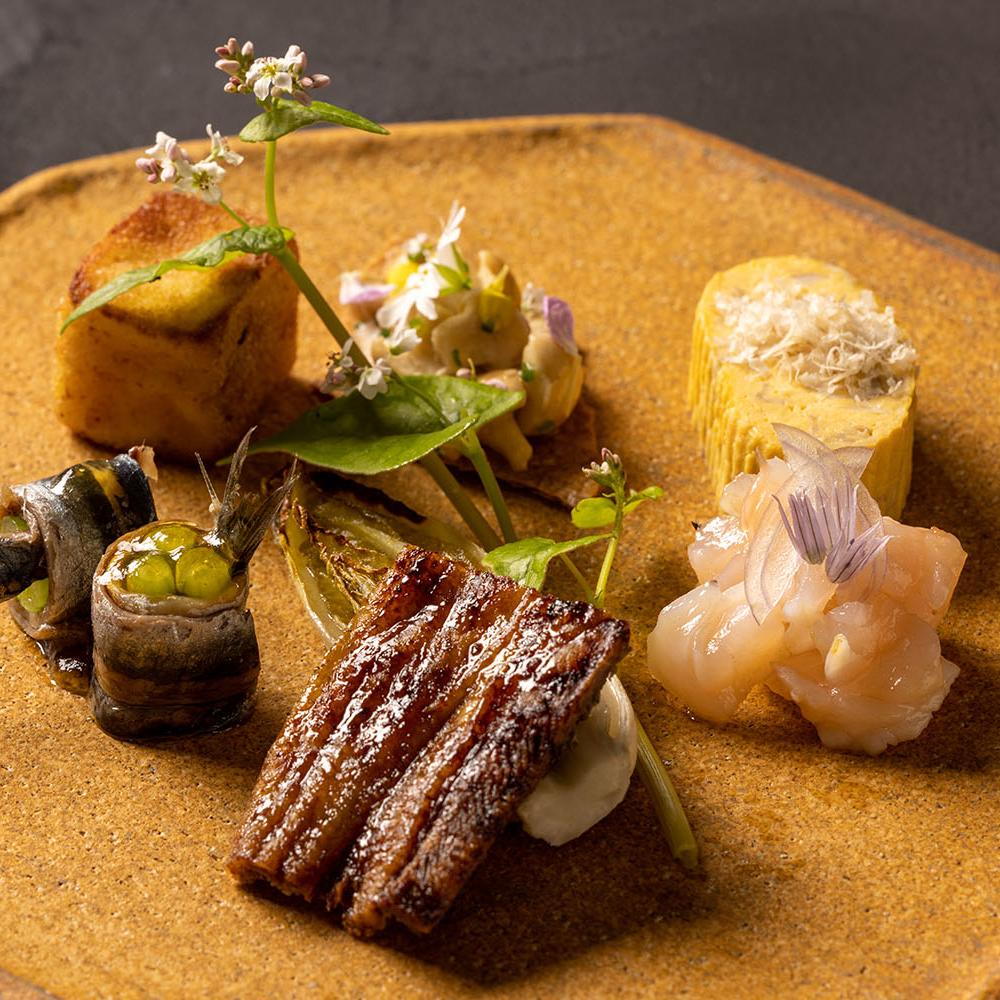 Plato de bienvenida con distintas preparaciones, entre las que destacan las Anchoas rellenas con brotes de daikon © Txispa