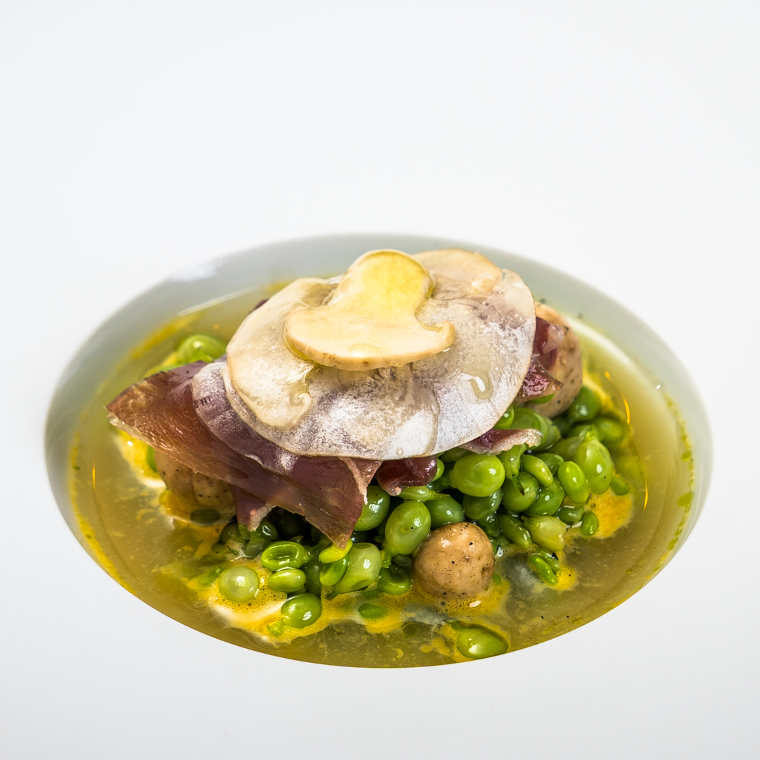 Guisantes lágrima a la brasa, con salsa ahumada de yema de huevo campero, perretxicos y consomé de ibérico © Ibai
