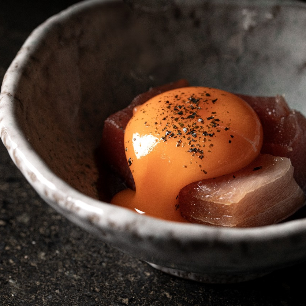 Tuna tataki topped with a bright orange egg yolk at Kuro (© Tati Frison/Kuro)